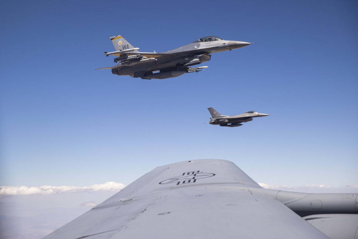 Two F-16s fly alongside a KC-135 Stratotanker as it refuels planes around the Nevada Test and T ...