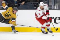 Golden Knights defenseman Dylan Coghlan (52) fights for a loose puck with Carolina Hurricanes c ...