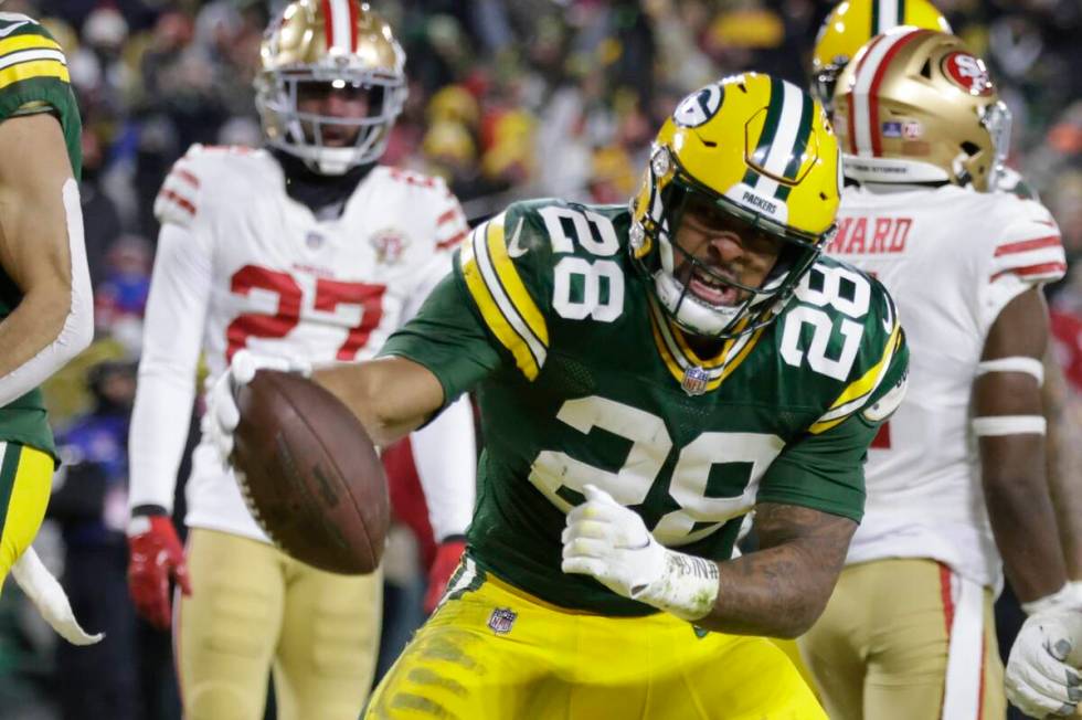 Green Bay Packers' A.J. Dillon (28) reacts after running for a touchdown during the first half ...