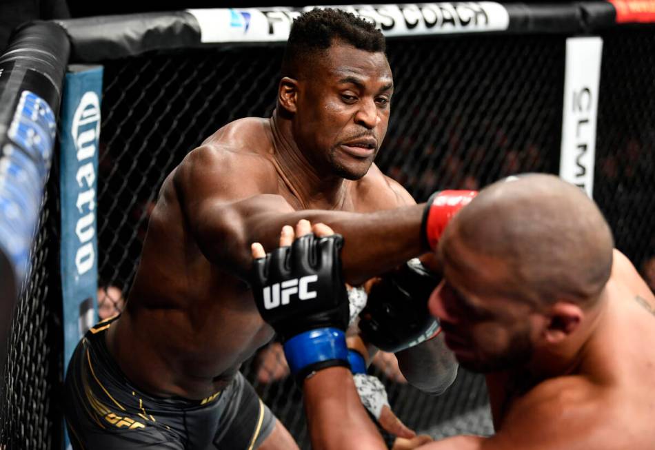 Francis Ngannou, left, of Cameroon punches Ciryl Gane of France in their UFC heavyweight champi ...