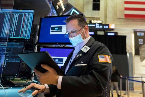 In this photo provided by the New York Stock Exchange, trader Edward Curran works on the floor, ...