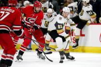 Vegas Golden Knights' Mark Stone (61) battles for the puck with Carolina Hurricanes' Jaccob Sla ...