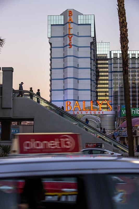 People exit down a pedestrian bridge in front of the exterior of Bally’s Las Vegas which ...