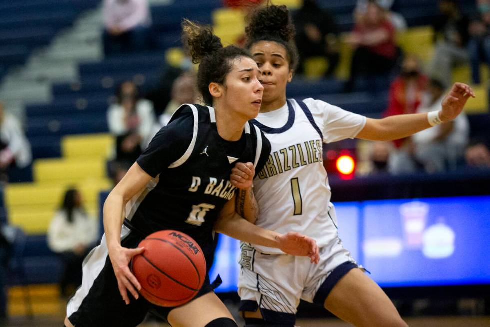 Desert Oasis’ Olivia Bigger (0) drives around Spring Valley’s Janiyah Davis (1) d ...