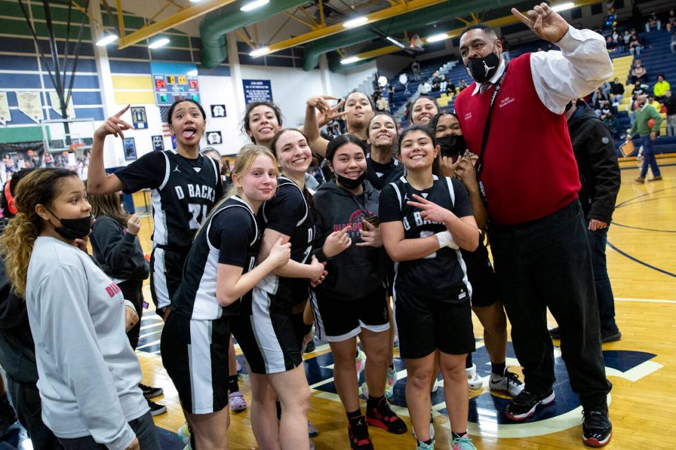 The Desert Oasis girls high school basketball team celebrates with a photo after winning a game ...