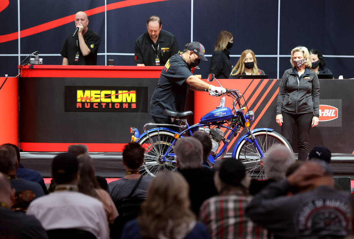 Auctioneer Russ Conklin calls bids on a 2005 Whizzer NE 5 at the Mecum Auctions vintage and ant ...