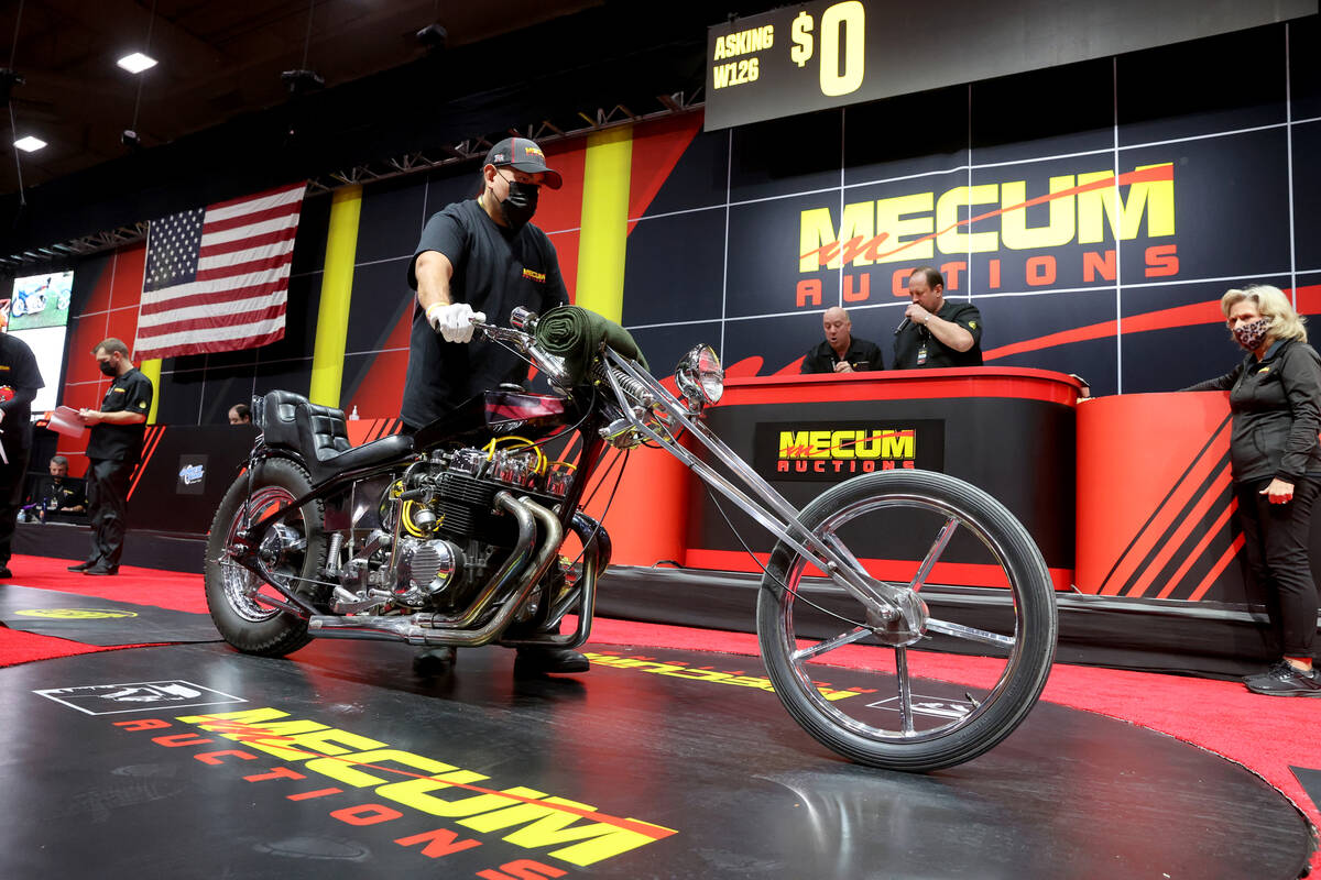A pusher moves a 1977 Spec Honda Chopper on the auction block at the Mecum Auctions vintage and ...