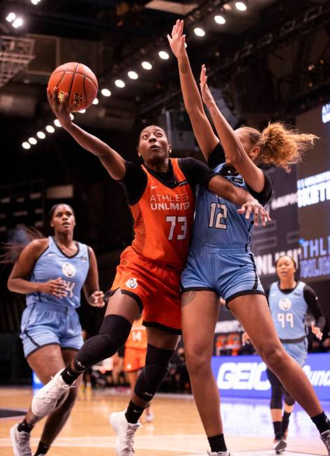 Team Russell’s Danielle McCray (73) slices to the rim past Team Sims’ Kiki Harrig ...