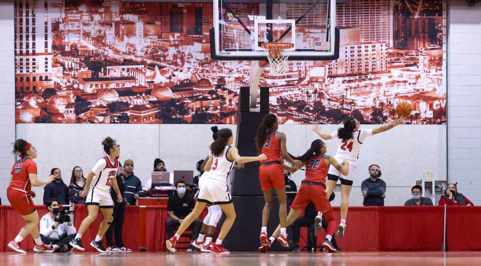 UNLV Lady Rebels guard Essence Booker (24) reaches for a rebound against the New Mexico Lobos d ...