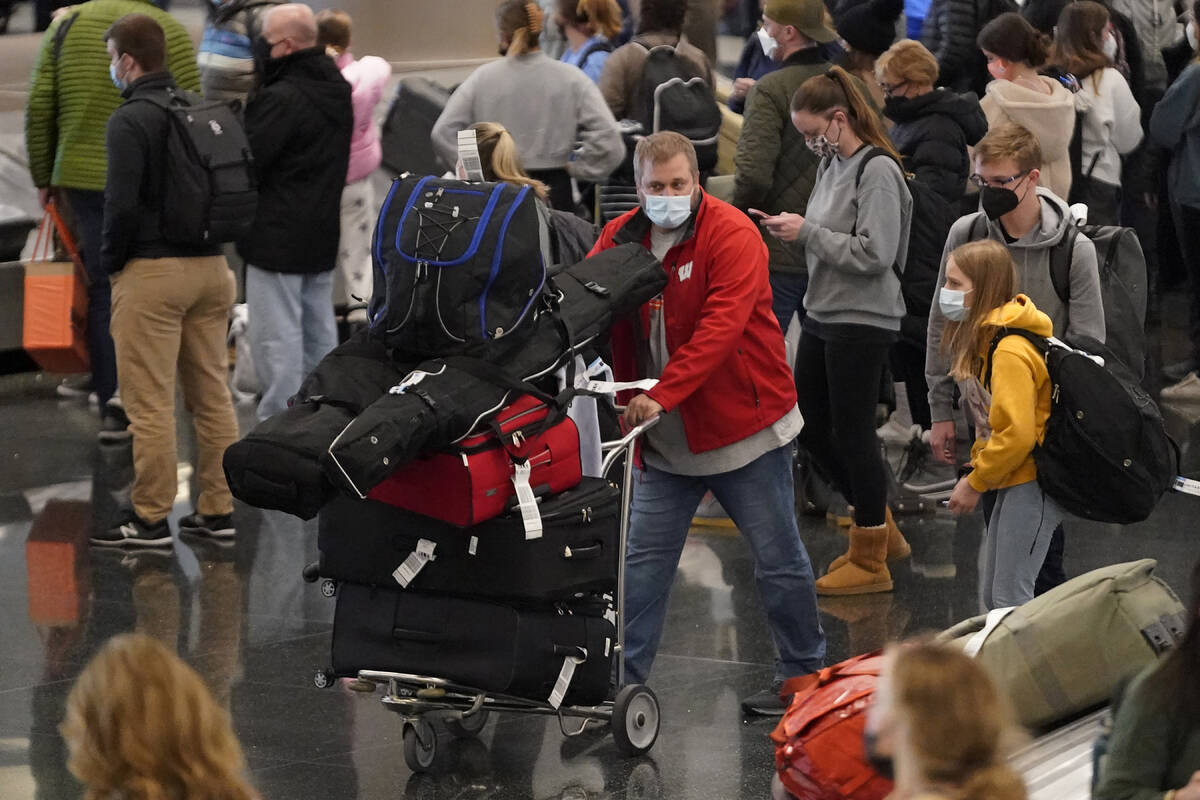 FILE - Travelers pass through Salt Lake City International Airport on on Dec. 27, 2021, in Salt ...