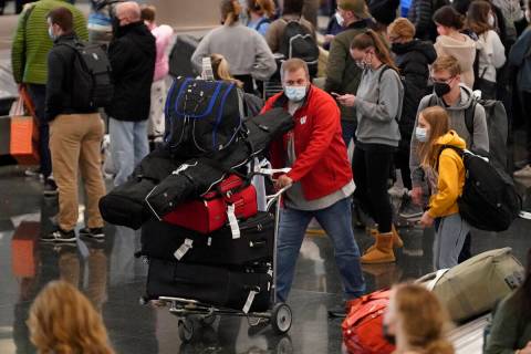 FILE - Travelers pass through Salt Lake City International Airport on on Dec. 27, 2021, in Salt ...