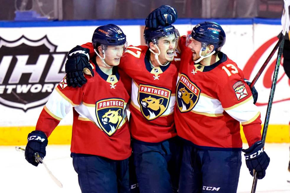 Florida Panthers left wing Mason Marchment, center, celebrates with center Anton Lundell, left, ...