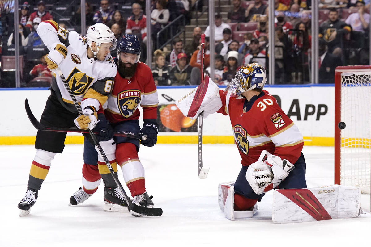 Vegas Golden Knights right wing Evgenii Dadonov, left, watches the puck go past Florida Panther ...