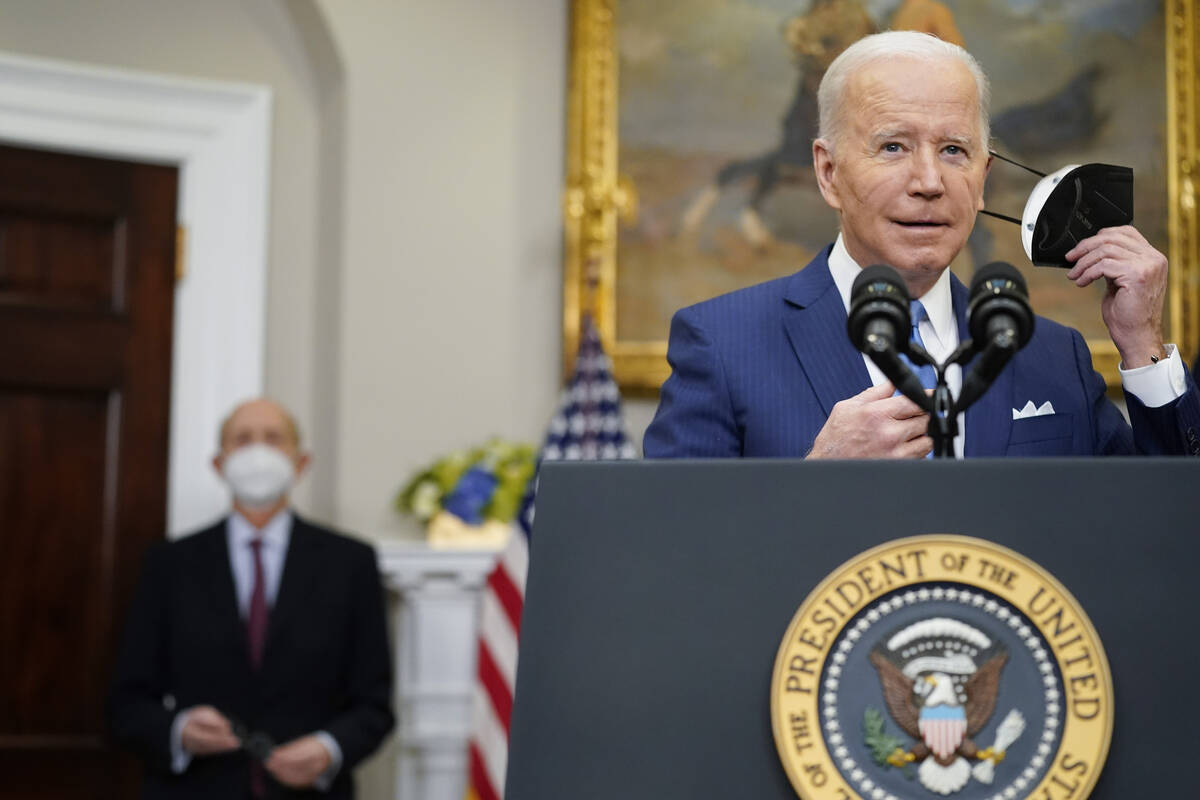 President Joe Biden removes his face mask as he prepares to deliver remarks on the retirement o ...