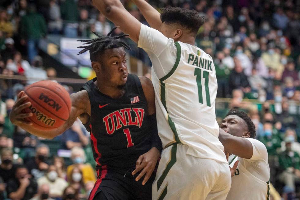 Colorado State forward Dischon Thomas (11) defends a pass under the basket by UNLV guard Michae ...