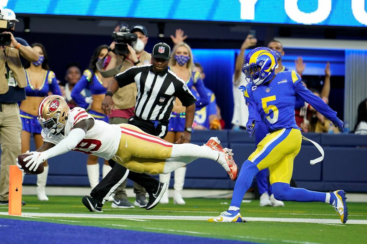 San Francisco 49ers' Deebo Samuel, bottom, dives into the end zone in front of Los Angeles Rams ...