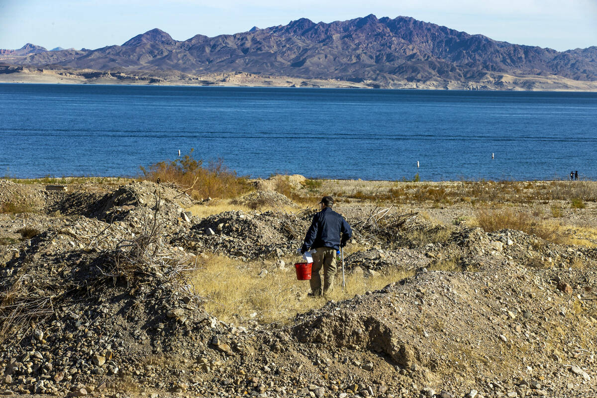 National Parks volunteer Doug Rorer picks up trash in a rocky area while joining Evolution Expe ...