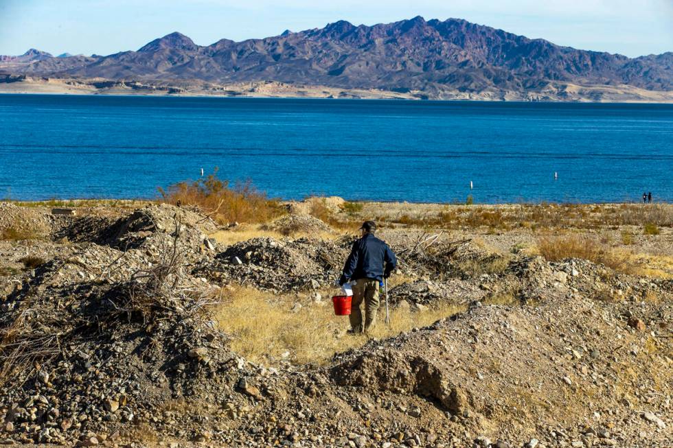 National Parks volunteer Doug Rorer picks up trash in a rocky area while joining Evolution Expe ...
