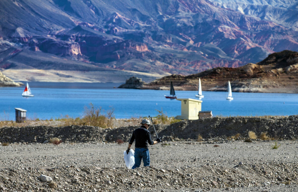 Volunteer Kevin Lang of Henderson with Get Outdoors Nevada combs the shoreline for trash as his ...