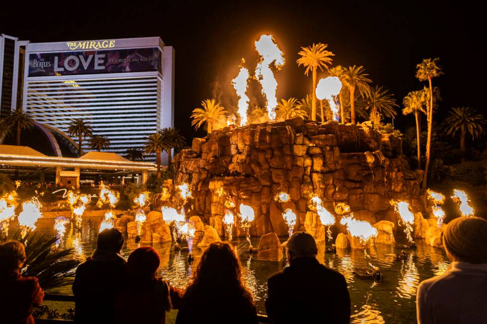 People watch the volcano show on the Strip outside the The Mirage on Wednesday, Jan. 26, 2022, ...