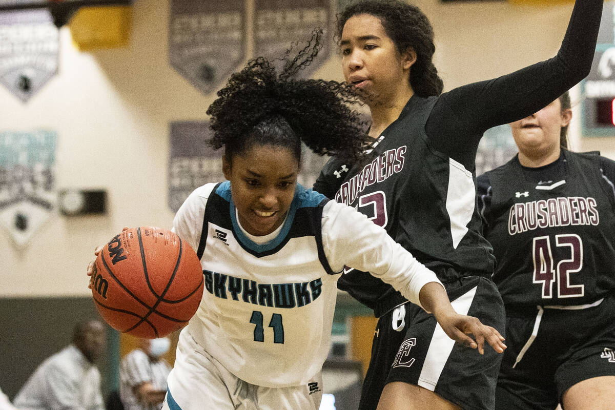 Silverado High's Ashley Saxton (11) drives past Faith Lutheran High's Ariel Thomas (22) during ...