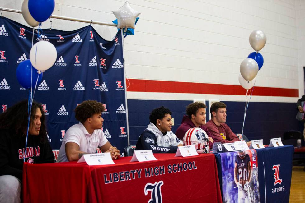 Liberty’s Saco Alofipo, center, who is committing to Utah State University, speaks along ...