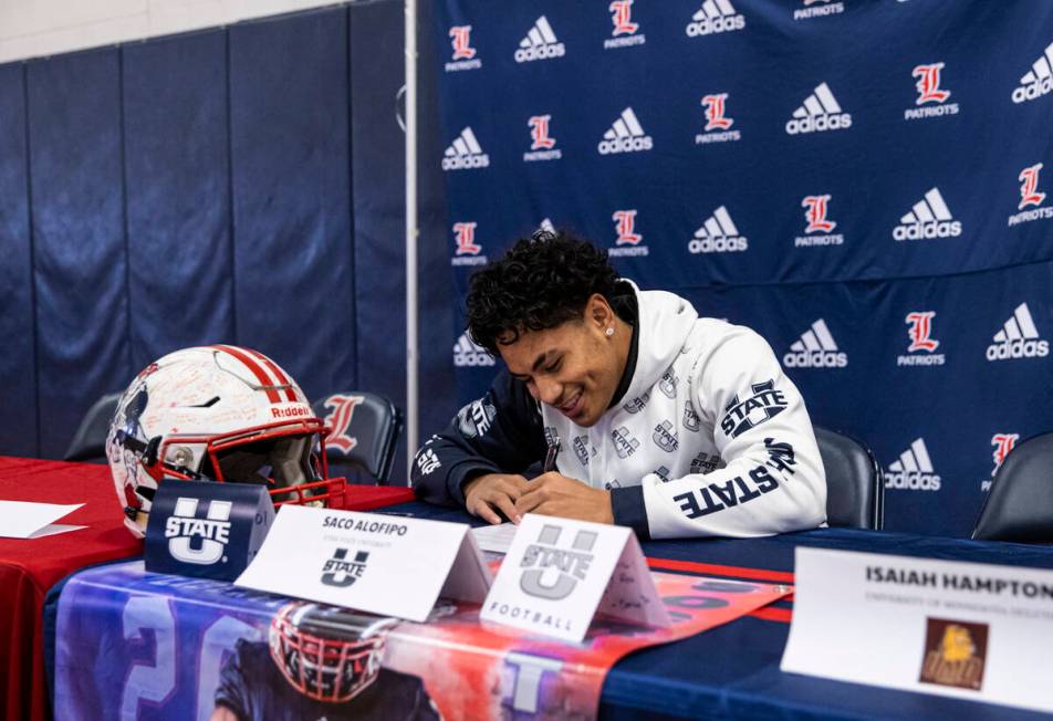 Liberty’s Saco Alofipo signs a letter of intent to play football at Utah State Universit ...