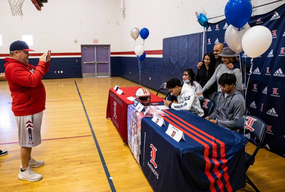 Liberty football coach Rich Muraco, left, takes a picture as Saco Alofipo signs a letter of int ...