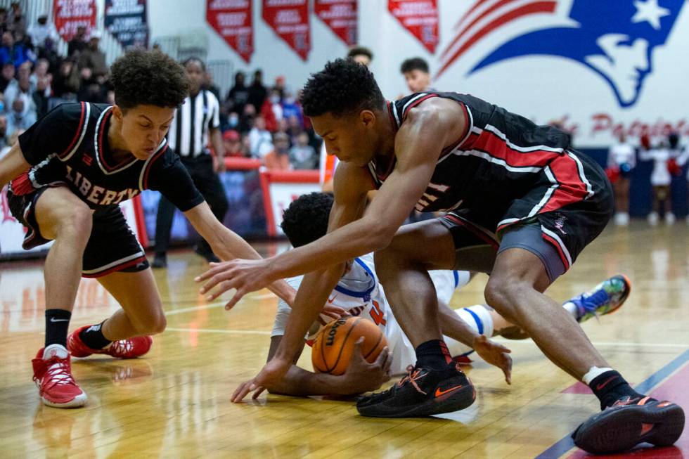 Liberty’s Angelo Kambala, left, and Joshua Jefferson, right, compete for the ball with B ...