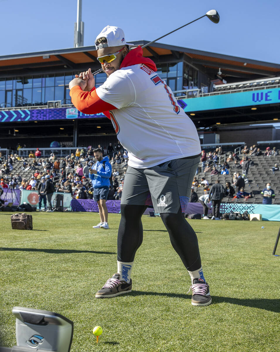 Buffalo Bills tackle Dion Dawkins readies to hit a golf ball in a driving skills game during AF ...