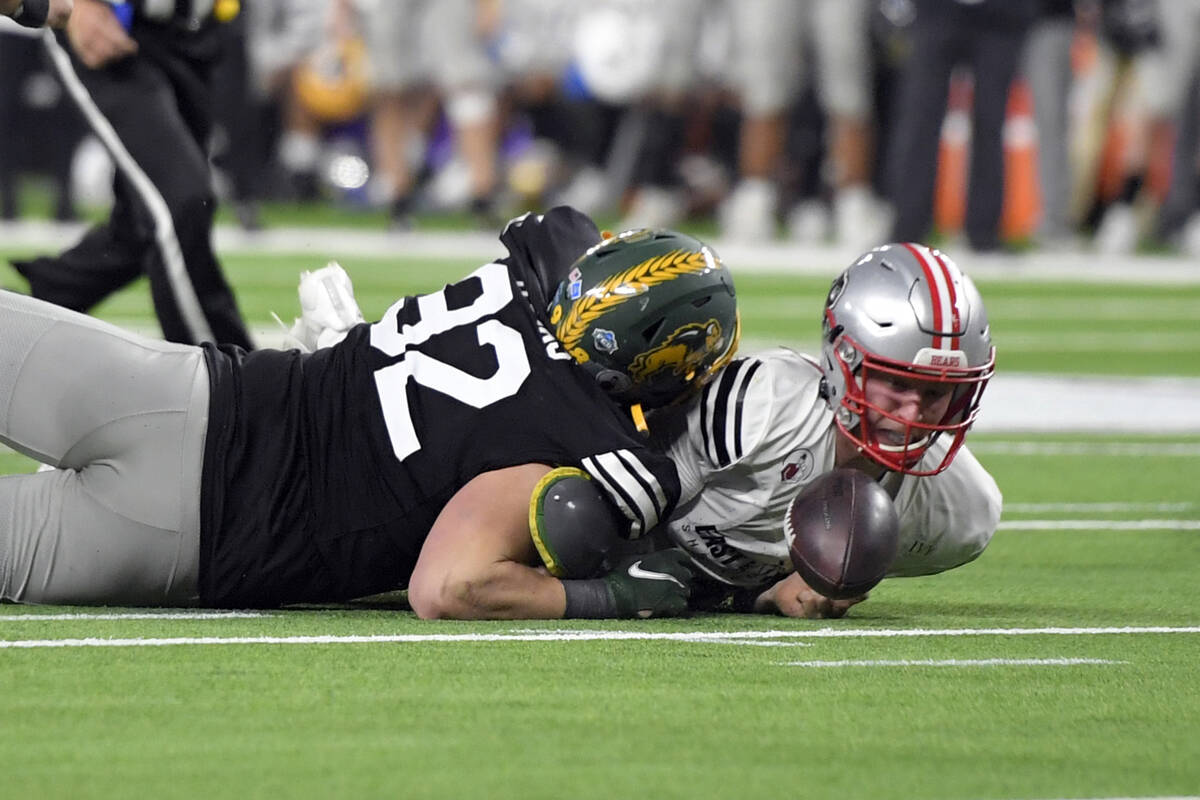 East quarterback EJ Perry (4), of Brown, looses the ball under pressure from West defensive end ...