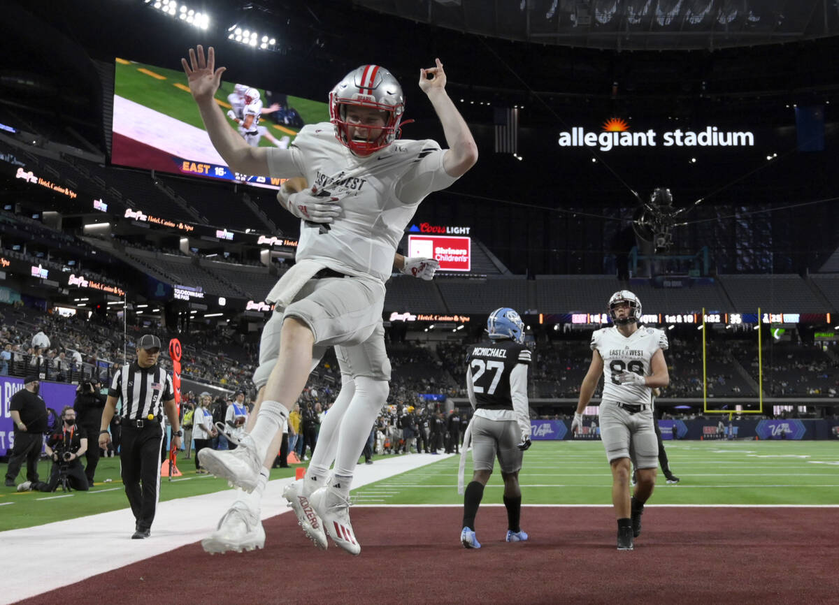 East quarterback EJ Perry (4), of Brown, celebrates with wide receiver Samori Toure (83), of Ne ...