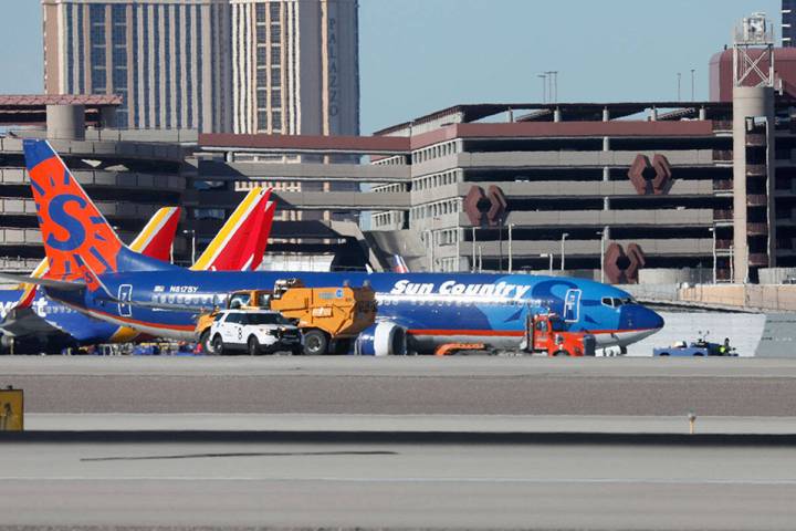 A Sun Country plane is towed away after making a hard landing at Harry Raid International Airpo ...