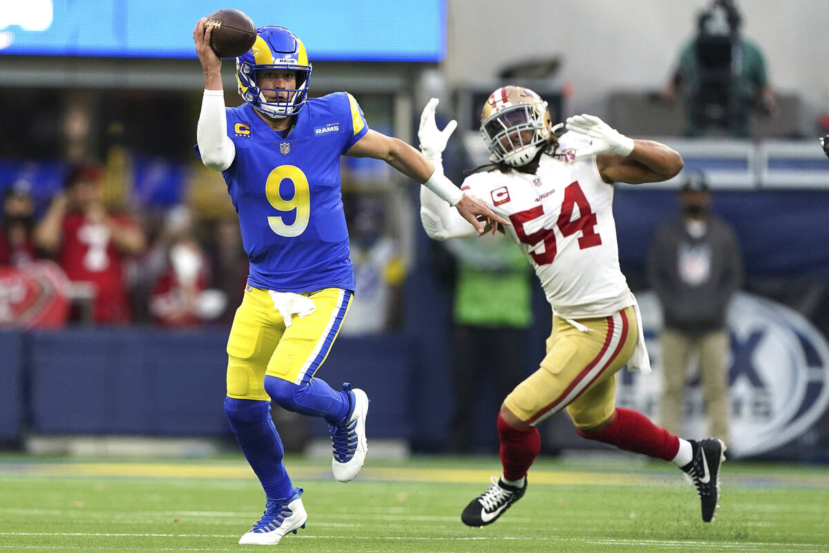 Los Angeles Rams quarterback Matthew Stafford (9) looks to pass while being chased by San Franc ...