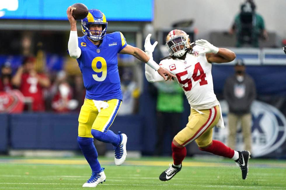 Los Angeles Rams quarterback Matthew Stafford (9) looks to pass while being chased by San Franc ...