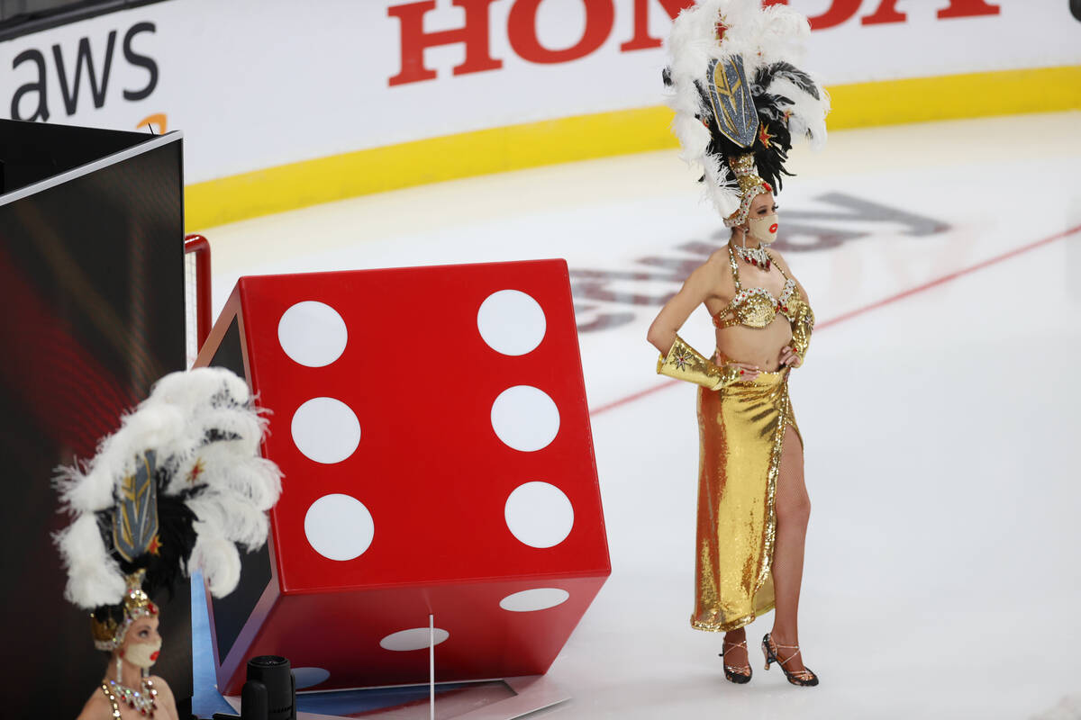 Showgirls stand on the ice for a pregame event during the NHL All-Star Game at T-Mobile Arena i ...