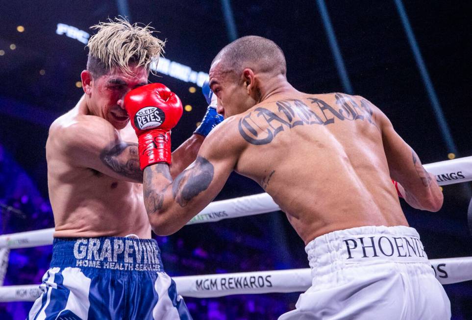 Leo Santa Cruz, left, takes a pinch in the face from and Keenan Carbajal during the second roun ...