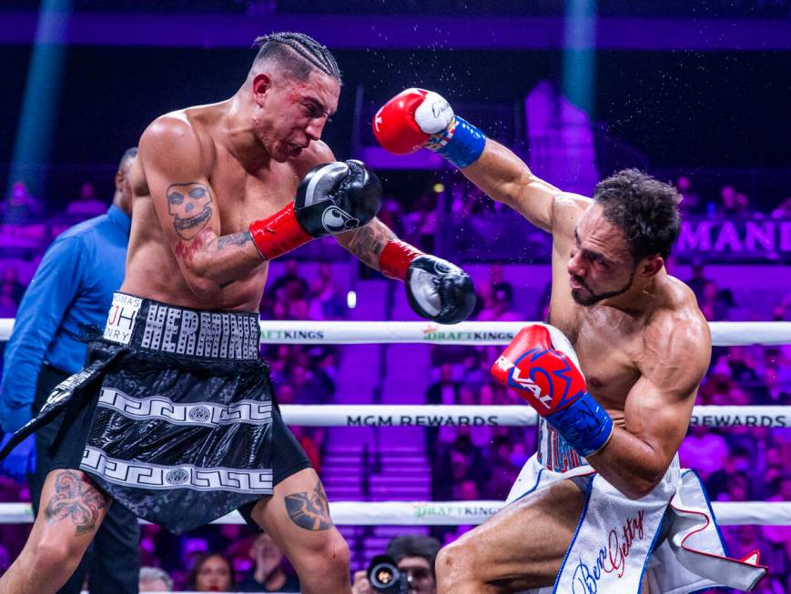 Mario Barrios, left, takes a punch from Keith Thurman during the fourth round of their Welterwe ...