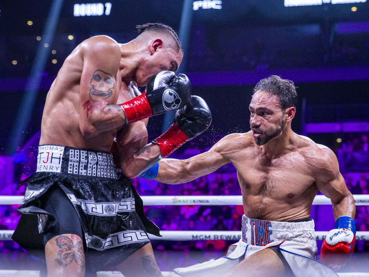 Mario Barrios, left, takes a punch to the ribs from Keith Thurman during the seventh round of t ...