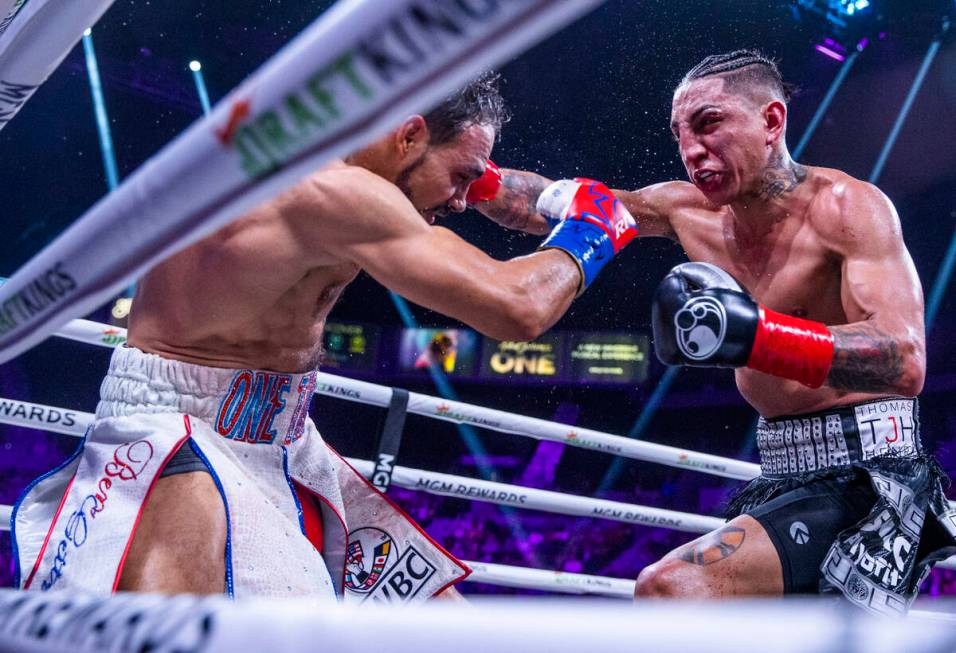 Keith Thurman, left, takes a punch to the head from Mario Barrios during the tenth round of the ...