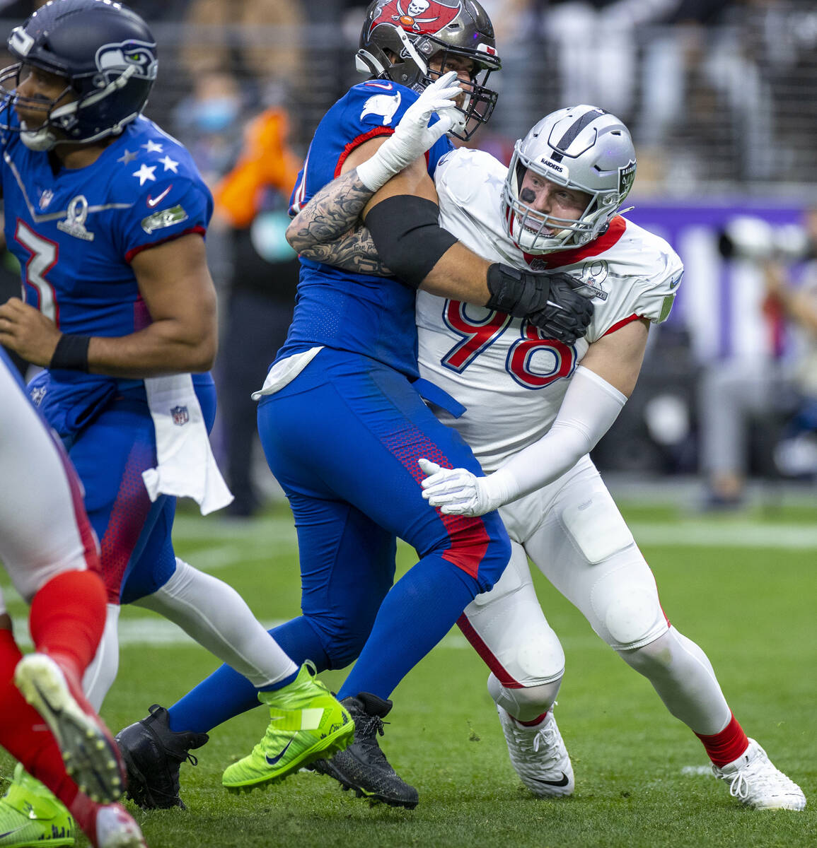 AFC defensive end Maxx Crosby of the Las Vegas Raiders (98) battles to get free of a hold by NF ...