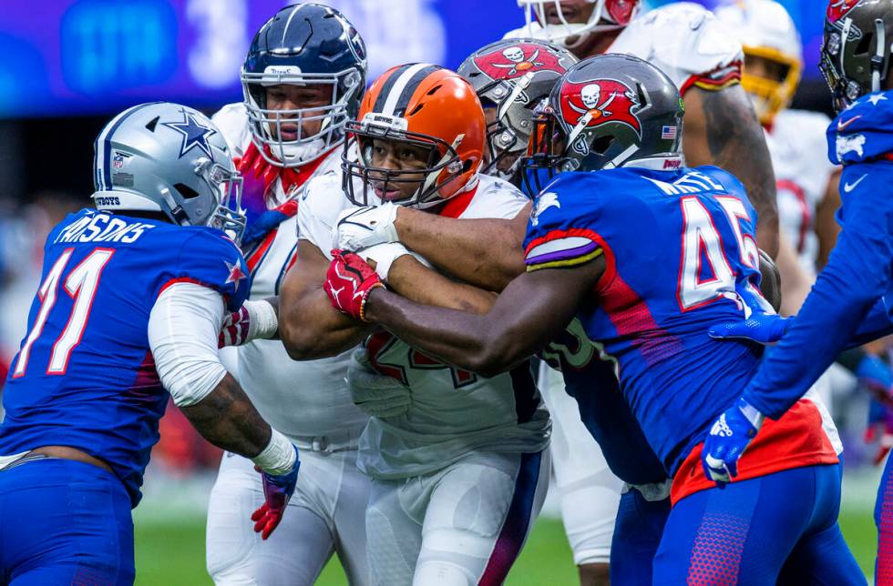 AFC running back Nick Chubb of the Cleveland Browns (24) is wrapped up by NFC inside linebacker ...