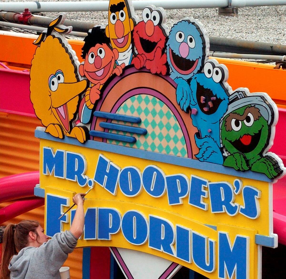 Tessa Meier puts some new paint on the sign outside Mr. Hooper's Emporium to get ready for open ...