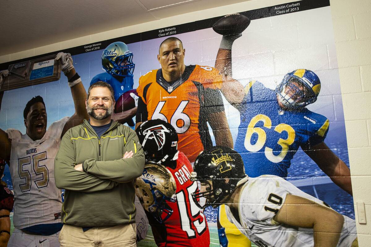 Former Reed High School football coach Ernie Howren poses next to a mural depicting former play ...