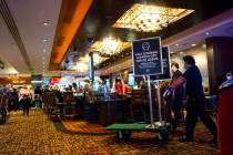 Signs requiring masks are carted away by staff at the Golden Nugget following the end of the ma ...