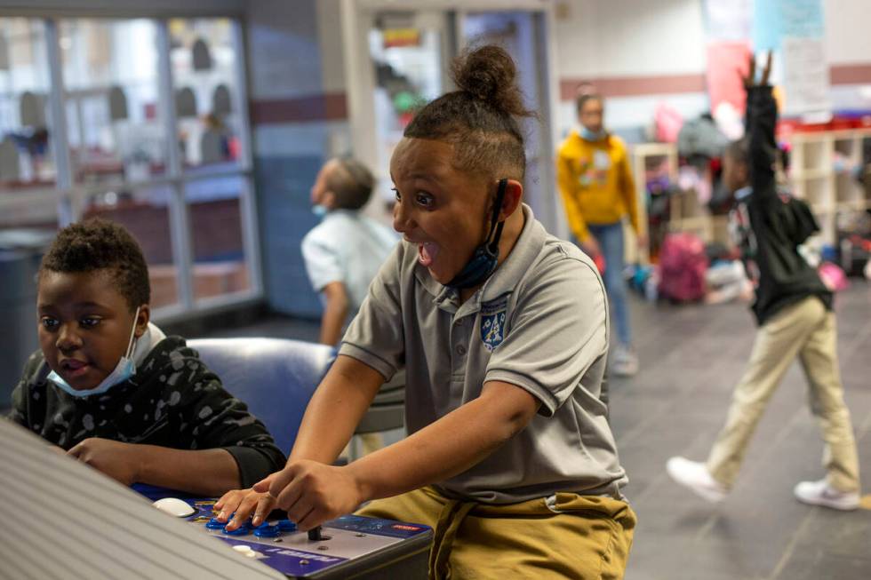 Izaiah Burnam, left, and Josiah Gill, center, play video games during the after-school program ...