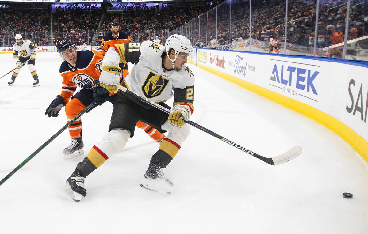 Vegas Golden Knights' Brett Howden (21) and Edmonton Oilers' Tyson Barrie (22) battle for the p ...