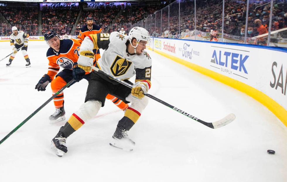 Vegas Golden Knights' Brett Howden (21) and Edmonton Oilers' Tyson Barrie (22) battle for the p ...