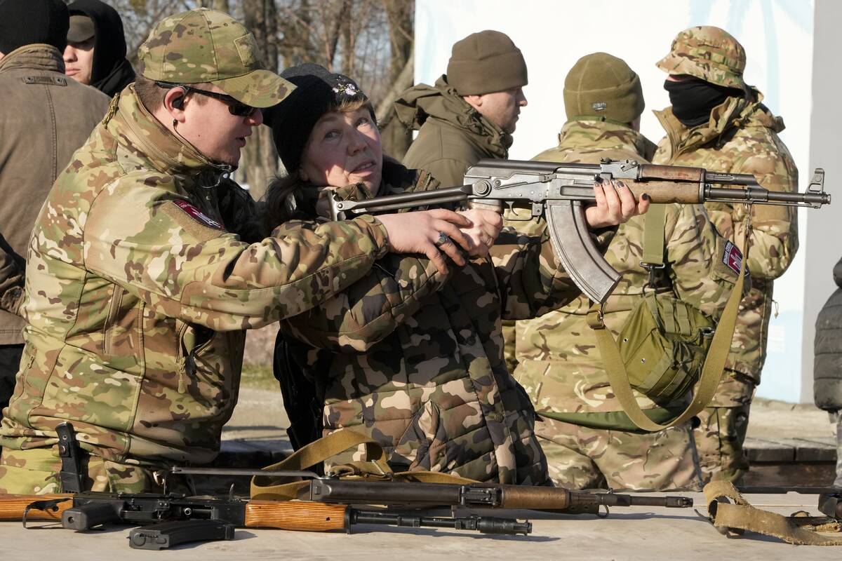 An instructor shows a woman how to use a Kalashnikov assault rifle, as members of a Ukrainian f ...