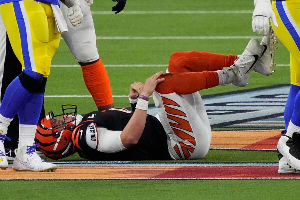 Cincinnati Bengals quarterback Joe Burrow (9) lies on the turf after being sacked during the se ...